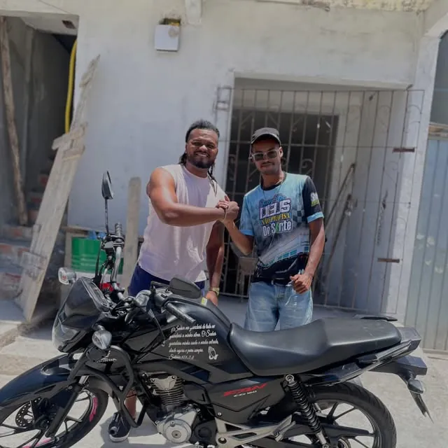 Gilvan cumprimentando um cliente ao lado da Honda Fan 160 alugada