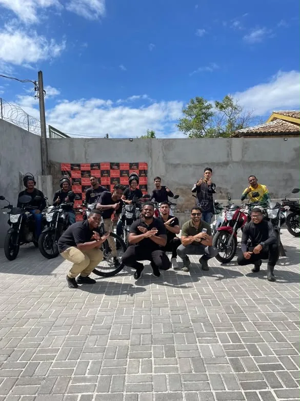 Grupo de motociclistas da Aladdin Motos reunido com as motos no pátio da loja