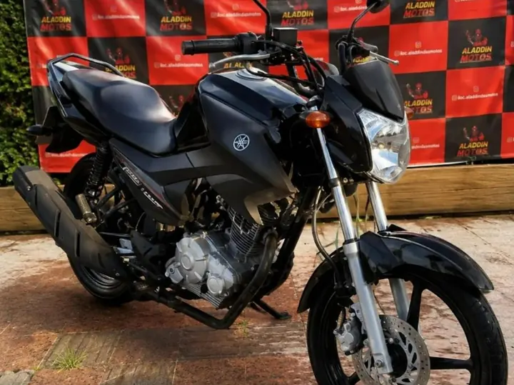 Yamaha Factor 150 preta em frente ao painel da Aladdin Motos